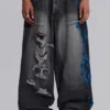 Colossus Jeans XL noir déchiré avec motif Spike Airbrush